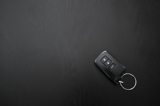 Remote Controlled Car Key On The Black Wooden Background, Top View.