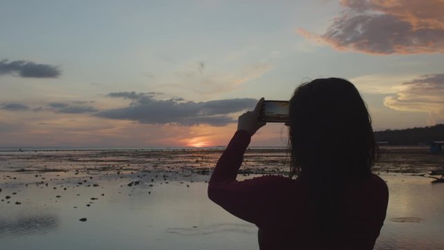 Back Shot Of A Milllenial Girl Taking A Photo Of Sunset