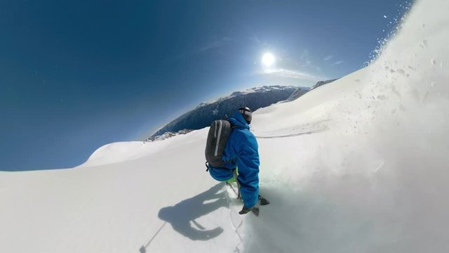 VIRTUAL REALITY 360: Snowboarder rides off piste with a spectacular view of British Columbia. Unrecognizable active male tourist shredding fresh powder off piste in Canada on a perfect winter day.