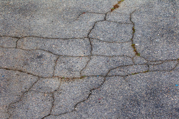 Old and cracked road surfaces are used to create the background and design. Deep relief Cracks on the pavement. Worn road, very used or broken by the weather