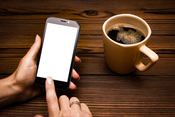 Female hands holding cup of coffee on wooden background