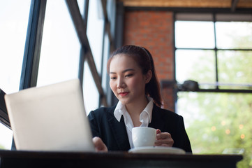 Beautiful girl working with a laptop in a coffee shop.