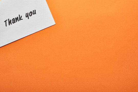 top view of thank you card on orange background