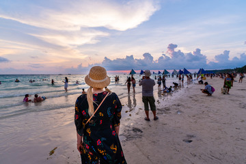 une femme voyant le coucher du soleil sur la plage blanche de Boracay
