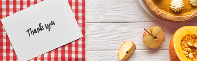top view of pumpkin pie with thank you card on wooden white table with apples, panoramic shot
