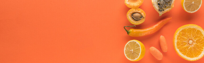top view of yellow fruits and vegetables on orange background with copy space, panoramic shot