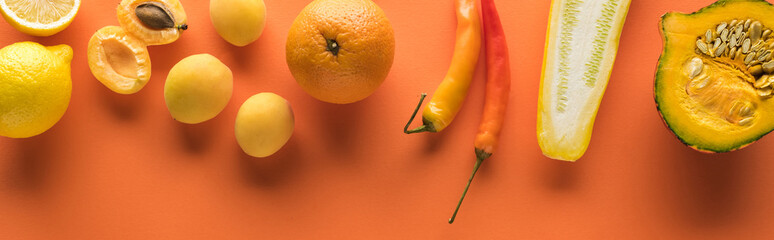 top view of yellow fruits and vegetables on orange background, panoramic shot