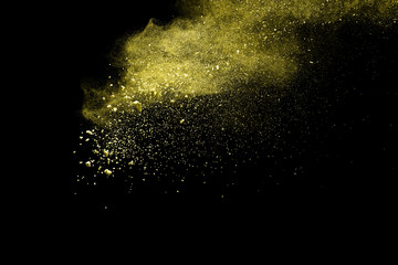 Yellow powder explosion on black background. Paint Holi.