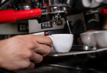 Fototapeta na wymiar Making espresso in white mug in coffeeshop or cafe closeup