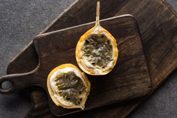 top view of sweet granadilla on wooden cutting boards on grey background