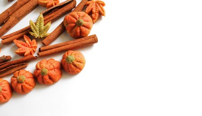 Pumpkin cookies on white background, Halloween gingerbread cookies with cinnamon sticks spices for trick or treat party holiday with copy space