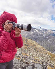 Obraz premium Tourist taking photo fin norwegian mountains
