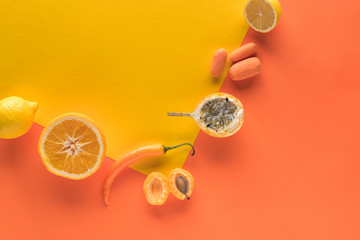 top view of yellow fruits and vegetables on orange background with copy space