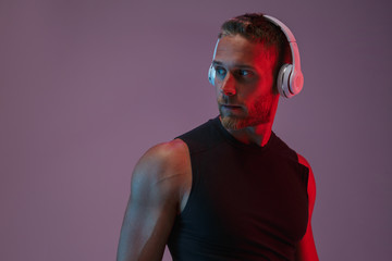 Naklejka premium Sports man posing isolated listening music with headphones.