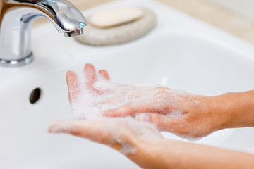 Hygiene concept. Washing hands with soap under the faucet with water