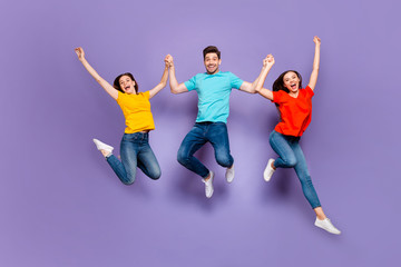 Full length size body photo of three group person having funny mood raising hands up dreams come true isolated violet background