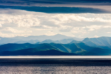 Landscape with lake and mountains in cloudy weather. Baikal Lake