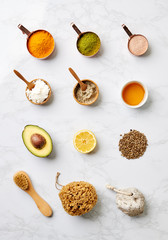 Overhead View Of Natural Beauty And Health Products In Measuring Cups On Marble Background