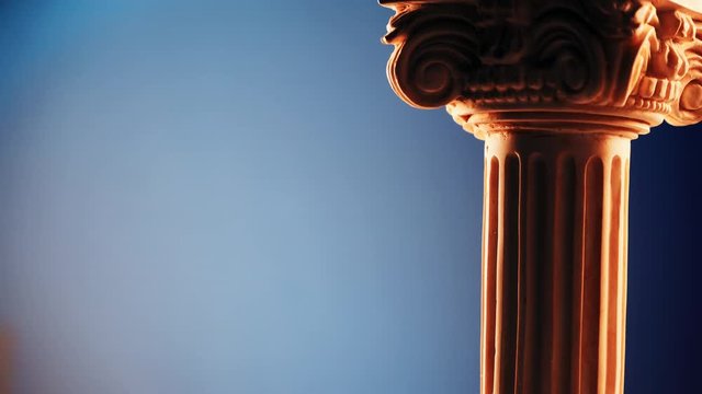 Single ancient column rotating slowly on blue background