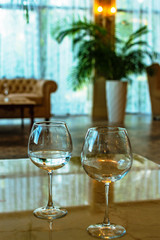 Two empty wine glasses on the hotel table. The reflection of the chandeliers, the conceptual event meeting wedding negotiations