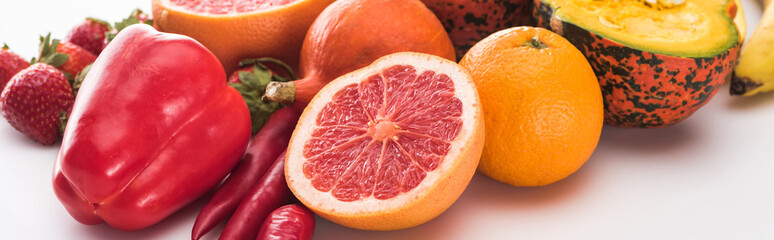 panoramic shot of peppers, strawberries, oranges and pumpkin on white background