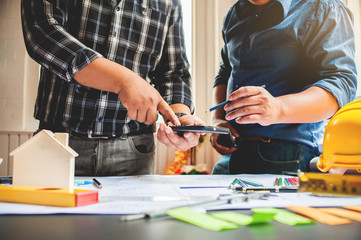 Architects and engineers are using a digital calculator to calculate the area of the housing village construction.