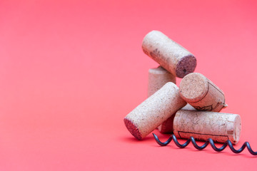 Wine corks with corkscrew on red background. Free copy space.