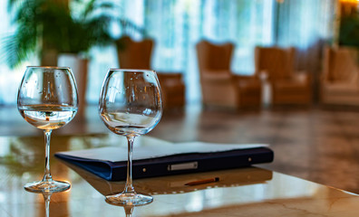 Two glasses of wine on the table hotel. Folder for pencil papers. The concept of business negotiations, meeting, collaboration.