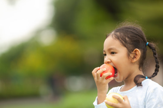  portrait of an asian girls eating apples with delicious outdoors