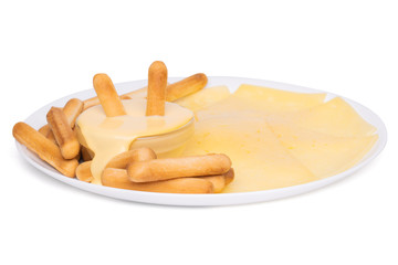 Grissini bread sticks in cheese sauce scattered on a white plate