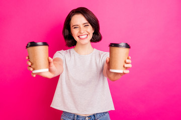 Photo of cheerful cute nice charming attractive sweet girlfriend smiling toothily proposing you choice of two coffee kinds wearing grey t-shirt jeans denim isolated with pink color vivid background