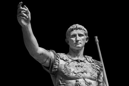 Caesar Augustus, the first emperor of Ancient Rome. Bronze monumental statue in the center of Rome isolated on black background