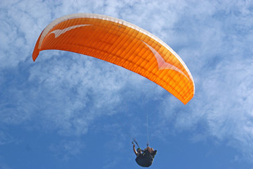Paraglider flying wing in a blue sky
