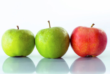 Three apples, one is red and the others are green colored isolated on white background, close up