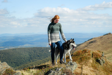 Girl runs with dog. The Husky are black and white. Hiking in the mountains. Carpathian Mountains