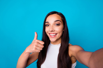 Closeup photo of pretty lady making selfies raising thumb up approving good product quality wear nice white tank top isolated blue color background