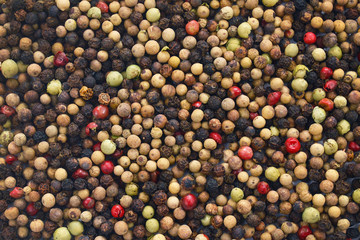 Top view background with whole red, white, green and black colored pepper corns