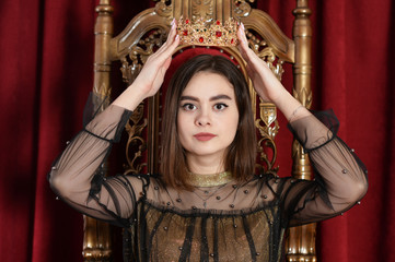 Close up portrait of a queen putting on crown