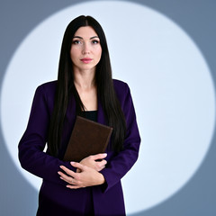 Portrait of a pretty brunette girl with long hair manager in a dark business suit in a circle of...