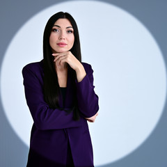 Portrait of a pretty brunette girl with long hair manager in a dark business suit in a circle of...