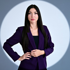 Portrait of a pretty brunette girl with long hair manager in a dark business suit in a circle of...
