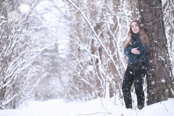 Naklejka premium Girl in a winter park in snowfall