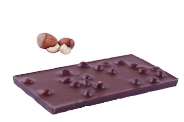 Hazelnut nuts and black chocolate on a white background