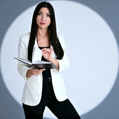 Portrait of a pretty brunette girl with long hair manager with a folder in her hands in a circle of...