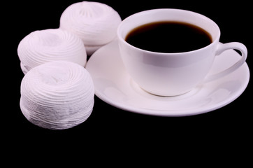 Cup of coffee and white marshmallows on a black background