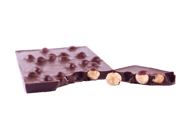 Hazelnut nuts in a black chocolate bar on a white background
