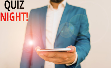 Word writing text Quiz Night. Business photo showcasing evening test knowledge competition between individuals Business concept with man holding mobile phone with touch screen