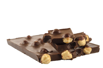 Pieces of chocolate with hazelnuts on a white background