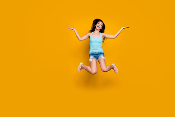 Fototapeta na wymiar Full length body size photo of cheerful charming cute nice excited ecstatic millennial youth jumping rejoicing with victory having won fun in jeans denim shorts isolated vibrant color background
