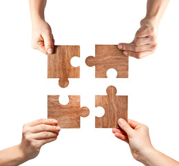 Four brown wooden puzzles in women hands